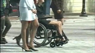 Cô gái tóc vàng ngồi xe lăn ở nơi công cộng